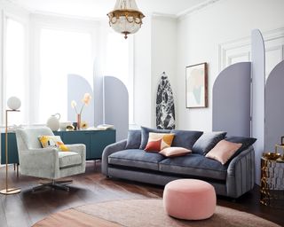 A living room with dark purple sofa and purple room dividers with chandelier light fixture