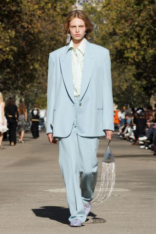 Model on the Stella McCartney runway styles a baby blue suit.
