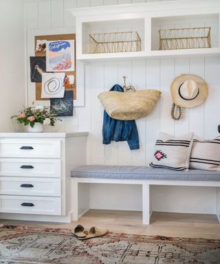 white mudroom storage with cushion bench, drawers, wall hooks and wire baskets - Mindy Gayer