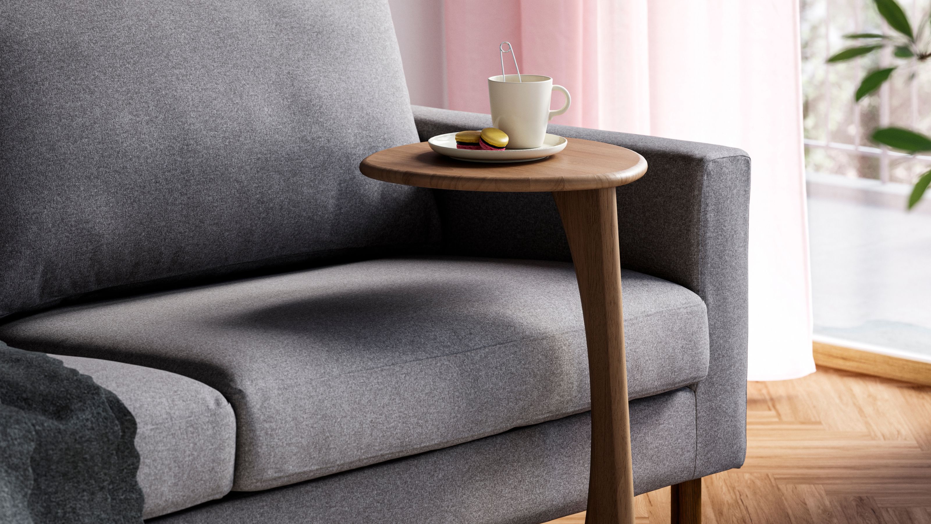 IKEA UGGLERUM Side Table in Brown in front of gray sofa with mug on top, pink sheer curtains, and timber floor