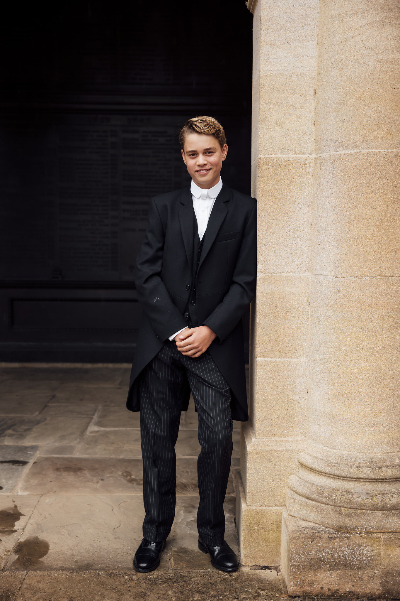 Prince George posing next to a column in his Eton uniform