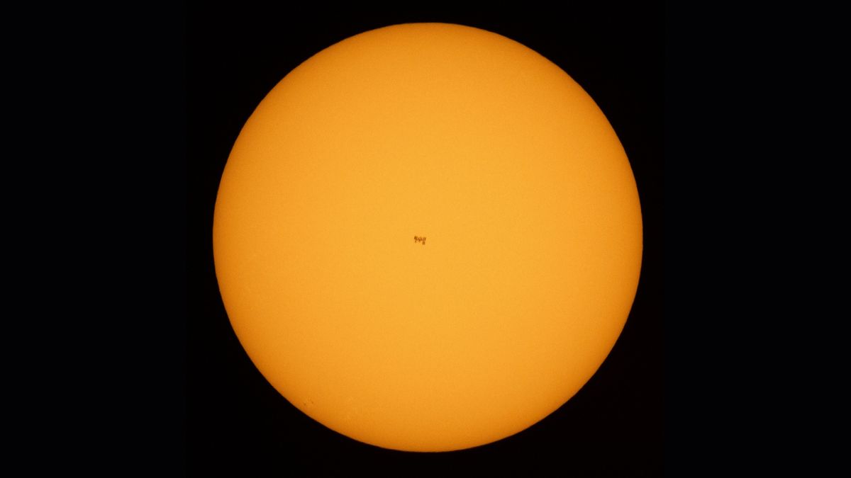 A view of the International Space Station in the center of the sun during a June 25, 2021 transit. Two astronauts, not visible here, were working outside the station at the time.