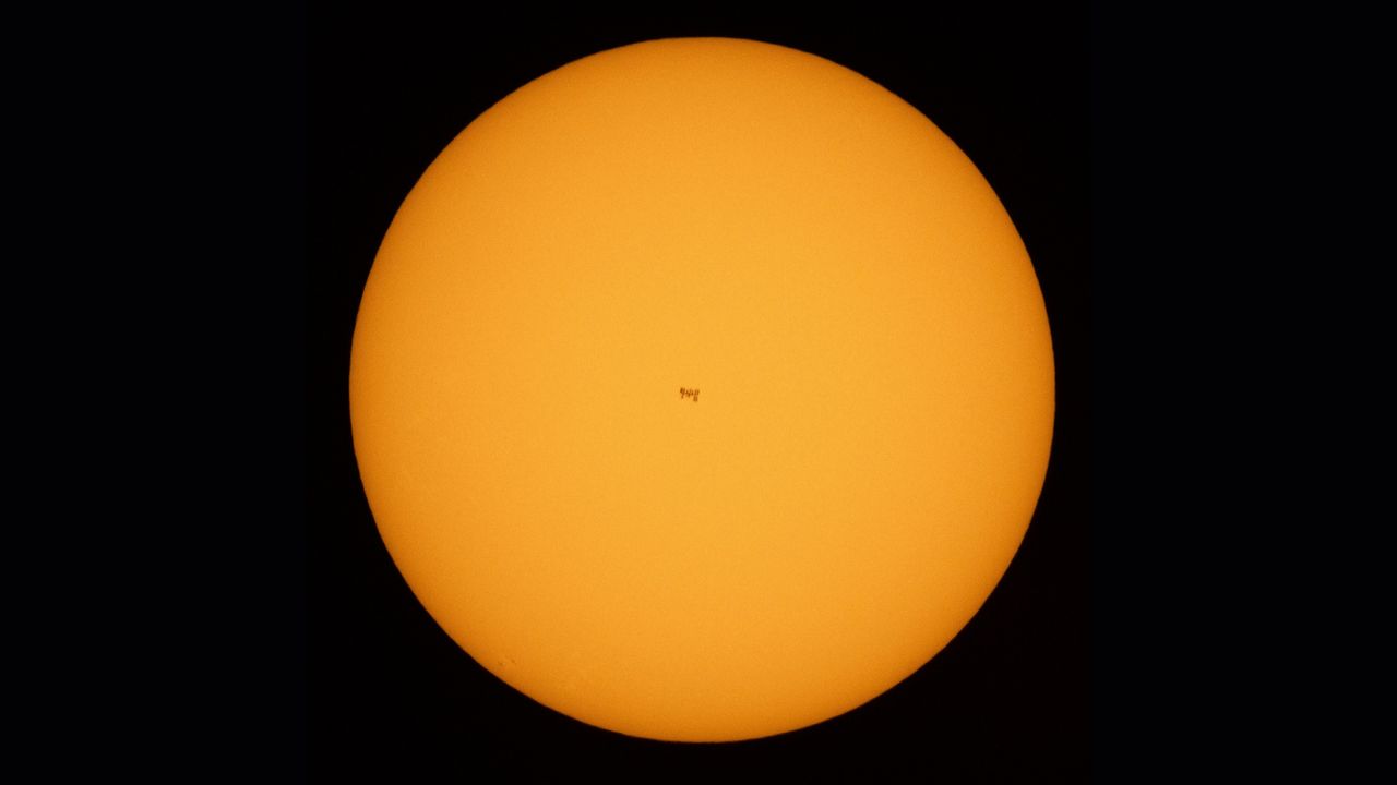 A view of the International Space Station in the center of the sun during a June 25, 2021 transit. Two astronauts, not visible here, were working outside the station at the time.