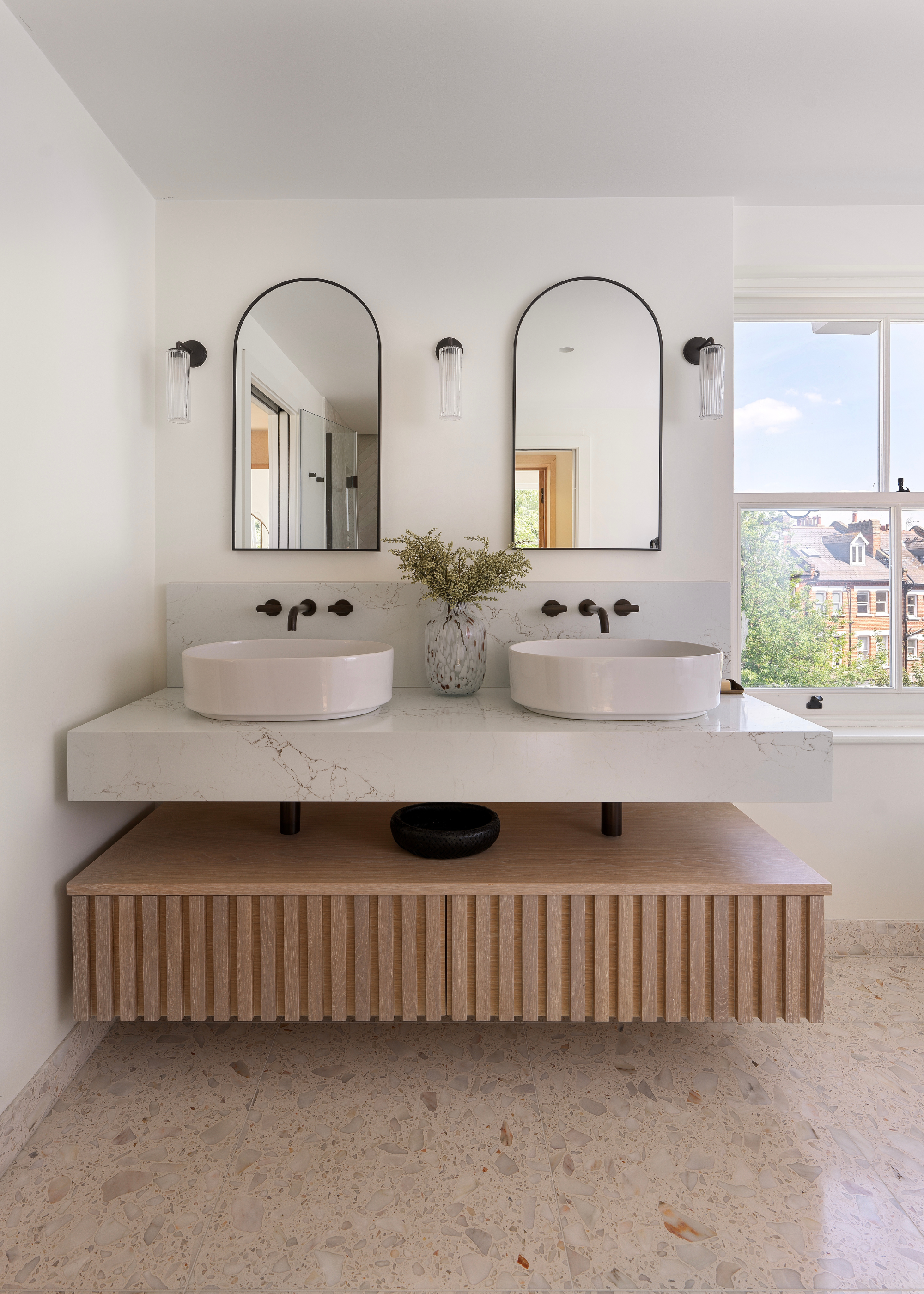 A contemporary take on a bathroom double vanity in natural materials and a neutral palette.