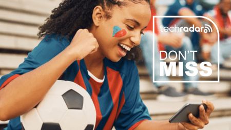 A girl with a soccer ball watching the match on her phone, with a TechRadar badge in white reading 'Don't Miss'