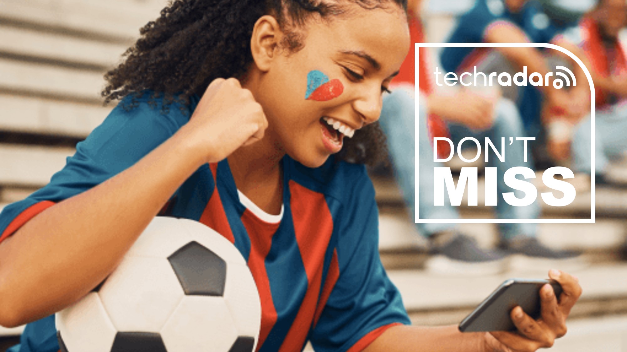 A girl with a soccer ball watching the match on her phone, with a TechRadar badge in white reading 'Don't Miss'