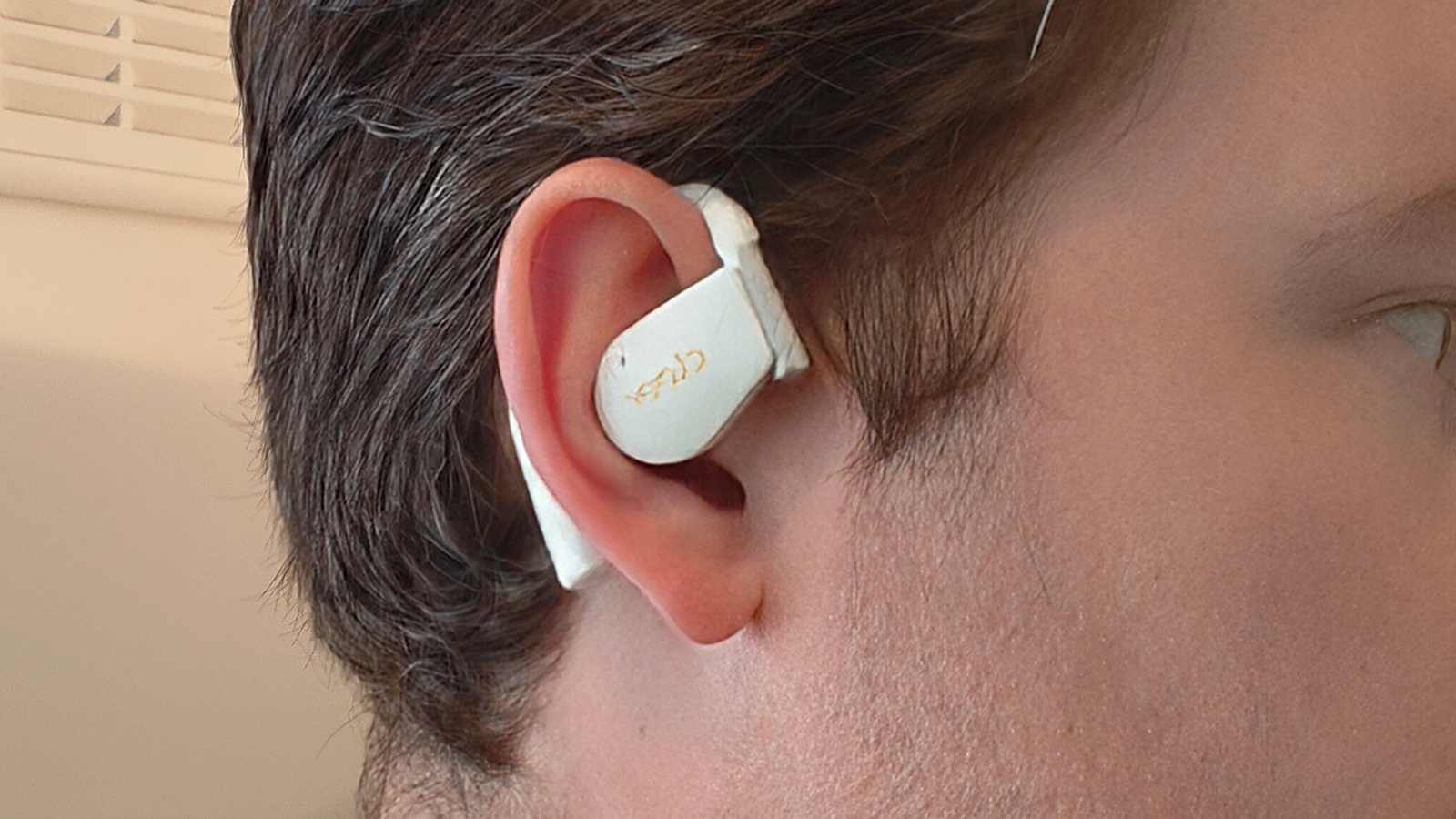 The Cleer Arc 5 on a man's ear.