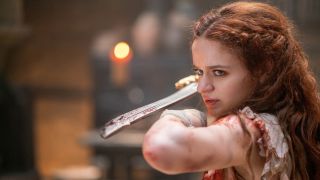 Joey King stands with sword raised before her in The Princess.