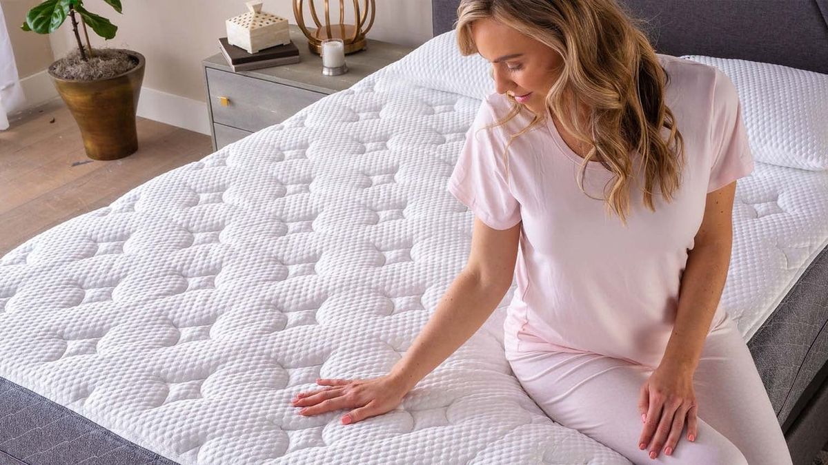 Woman in nightclothes sat on GhostBed Luxe cooling mattress