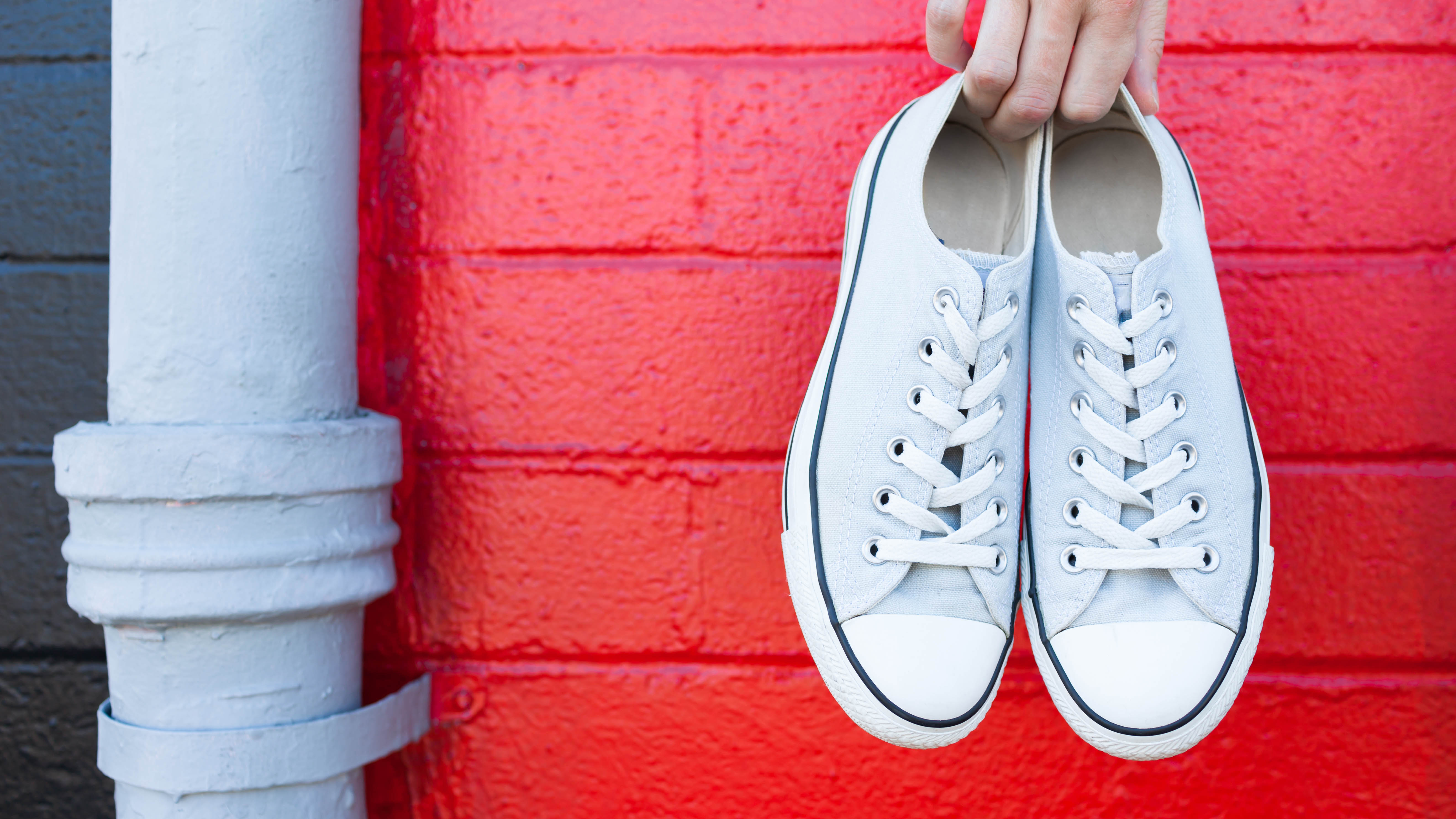 a pair of white shoes on a red wall