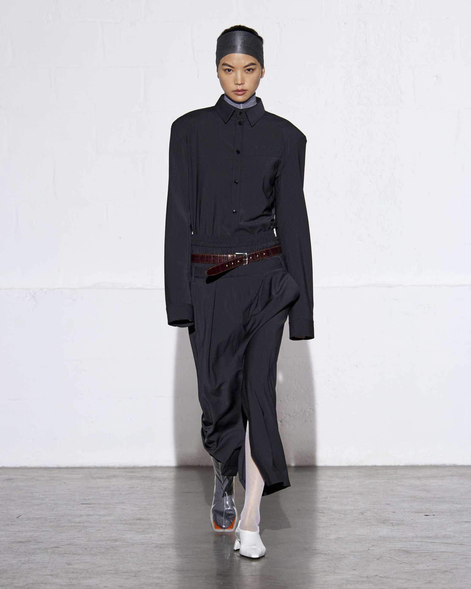 A Tibi model wearing a navy jacket and skirt with white tights at the F/W 24 show