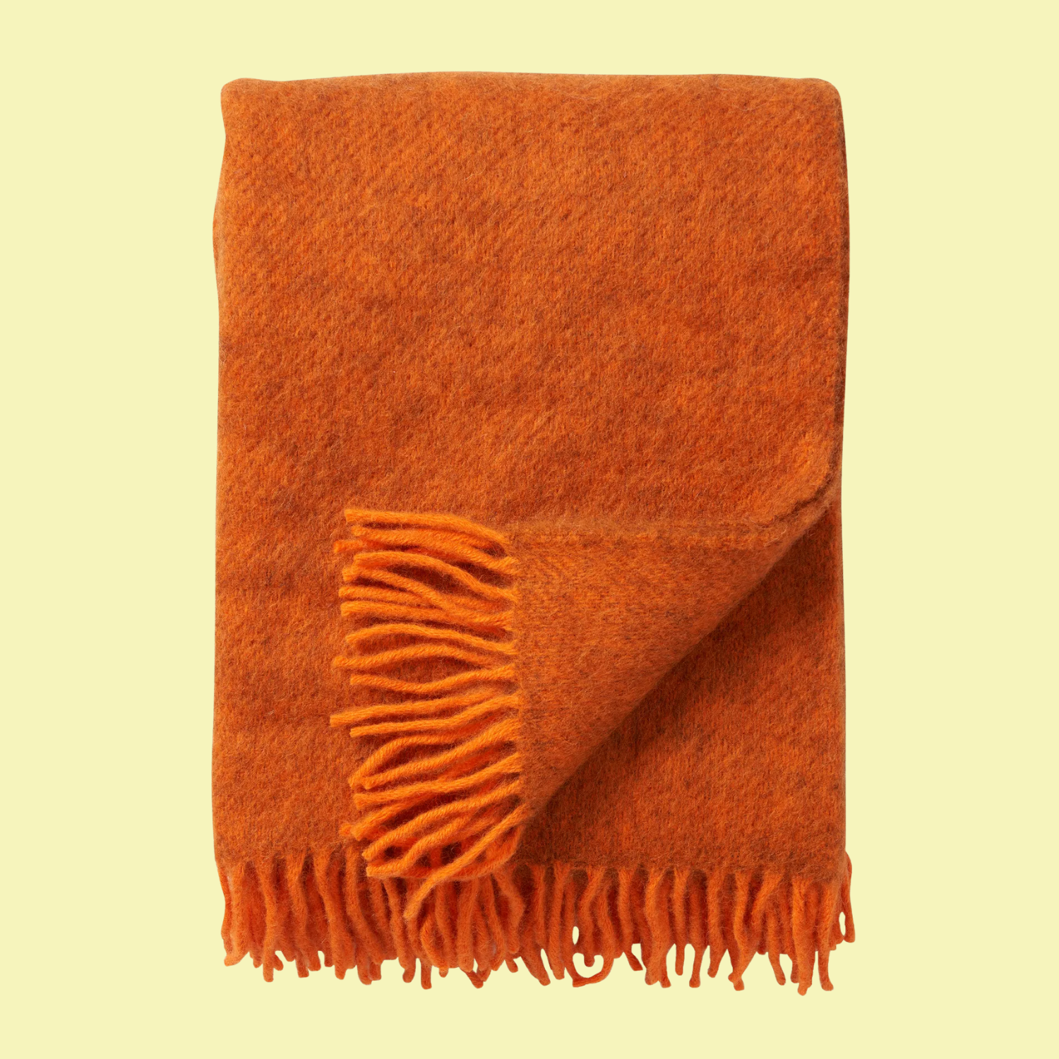 An orange throw with a fringe hem