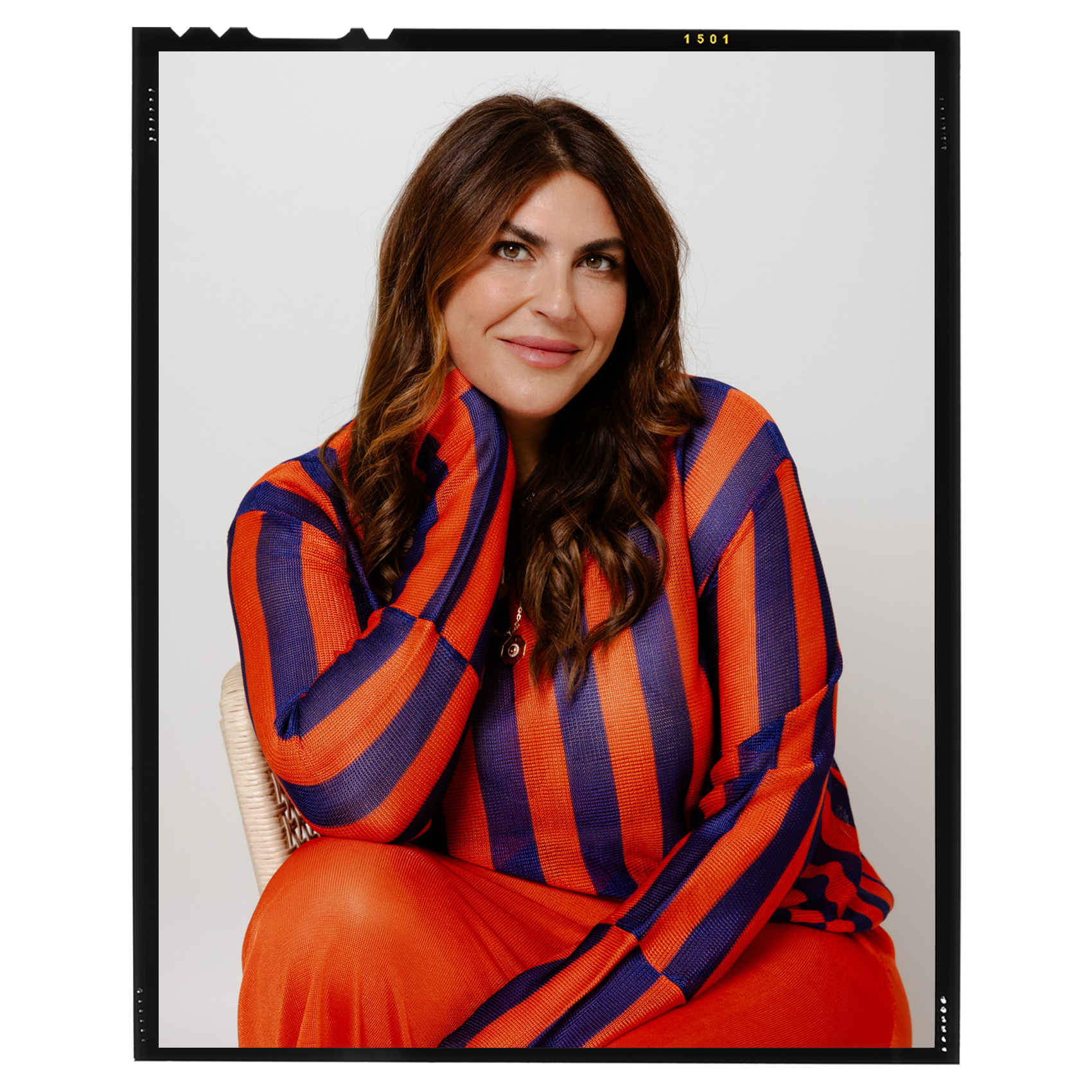 portrait of Katie Sturino in an orange and blue striped shirt and orange skirt