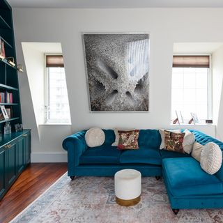 living room with blue L-shaped sofa and rug with two windows