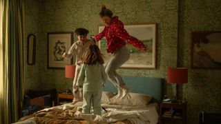 Bridget and her two children all in their pyjamas and jumping on the bed