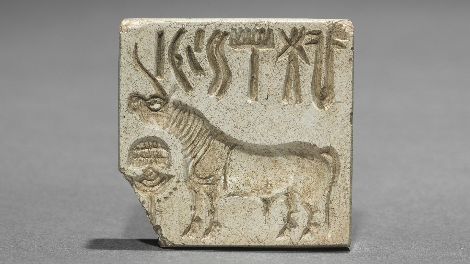 This photo shows a seal with a unicorn and above it an inscription in an ancient language.