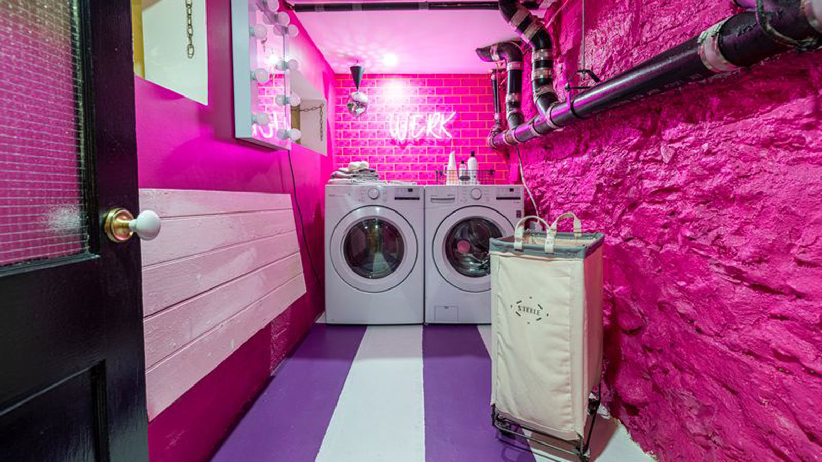 hot pink utility room with stripey floor and neon wall light