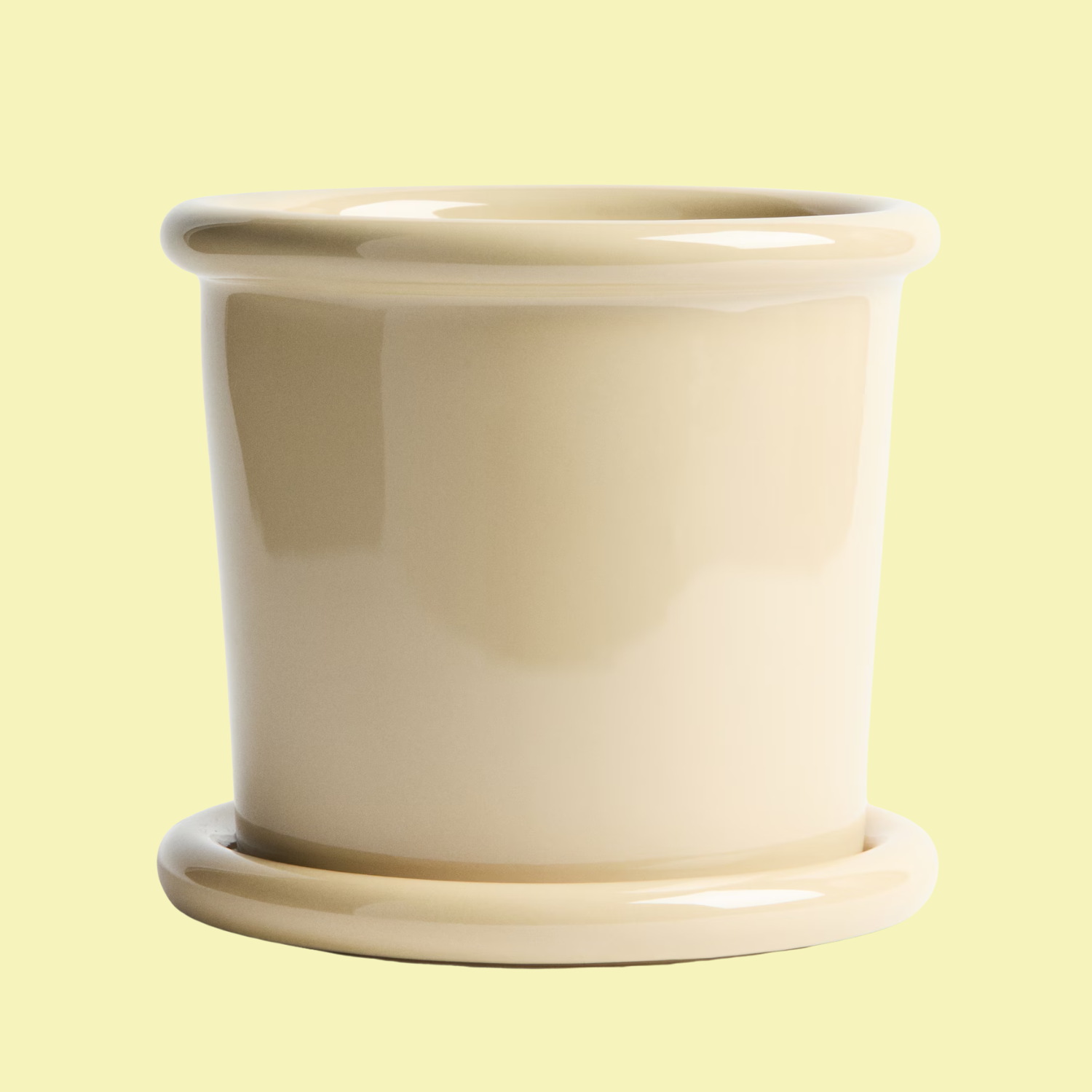 A pale yellow planter with a saucer