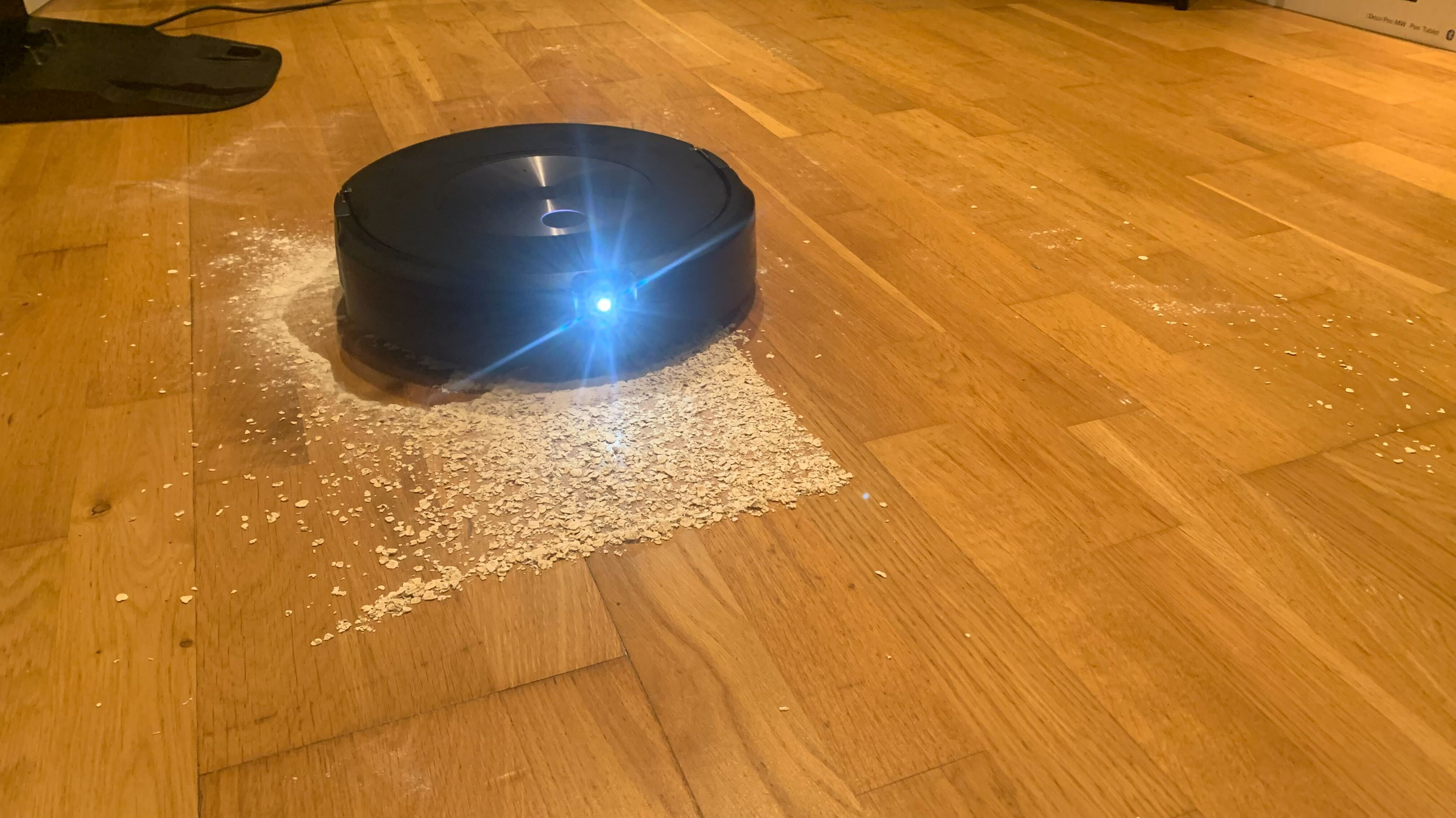 The floor with scattered oats and flour during the iRobot Roomba Combo j7+'s clean up of a heavy spill
