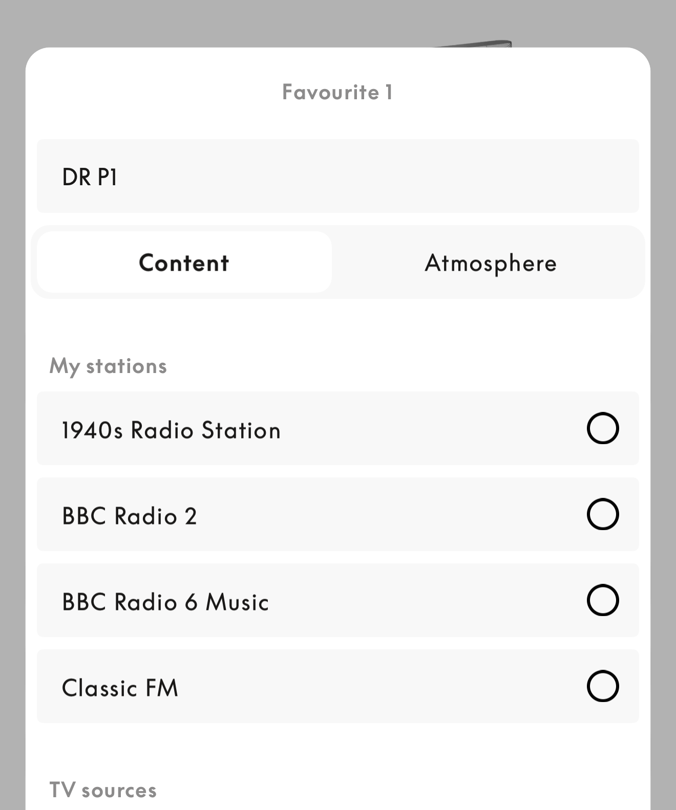 App screen showing Favorites settings with radio station options such as BBC Radio 2, BBC Radio 6 Music and Classic FM