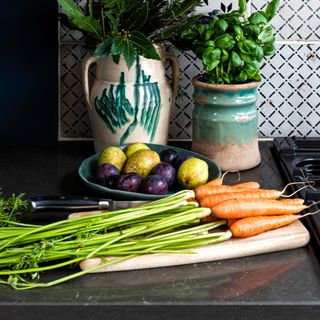 A bunch of carrots on a kitchen worktop