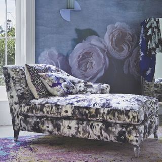 floral designed chaise lounge with floral cushions and blue wall with flowers design