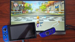 Original Nintendo Switch with Zelda Skyward Sword Joy-Con connected to KYY portable monitor with Mario Kart 8 Deluxe gameplay on screen.