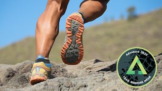 Close-up of man's feet wearing trail running shoes on rocky path