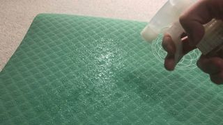 A yoga mat being sprayed with disinfectant