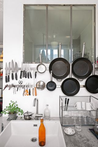 industrial kitchen with pans hanging on a metallic strip
