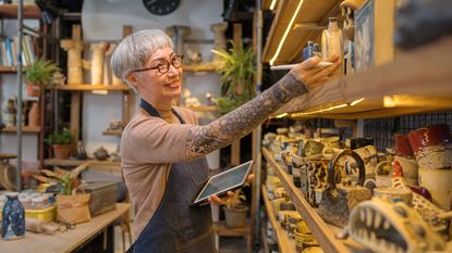 A woman looks at crafts on a shelf