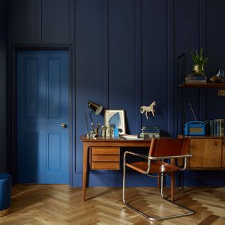 room with blue velvet matt panelling wall with wooden chair and table