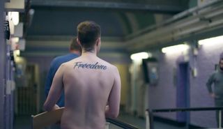 Back of prisoner with freedom tattoo