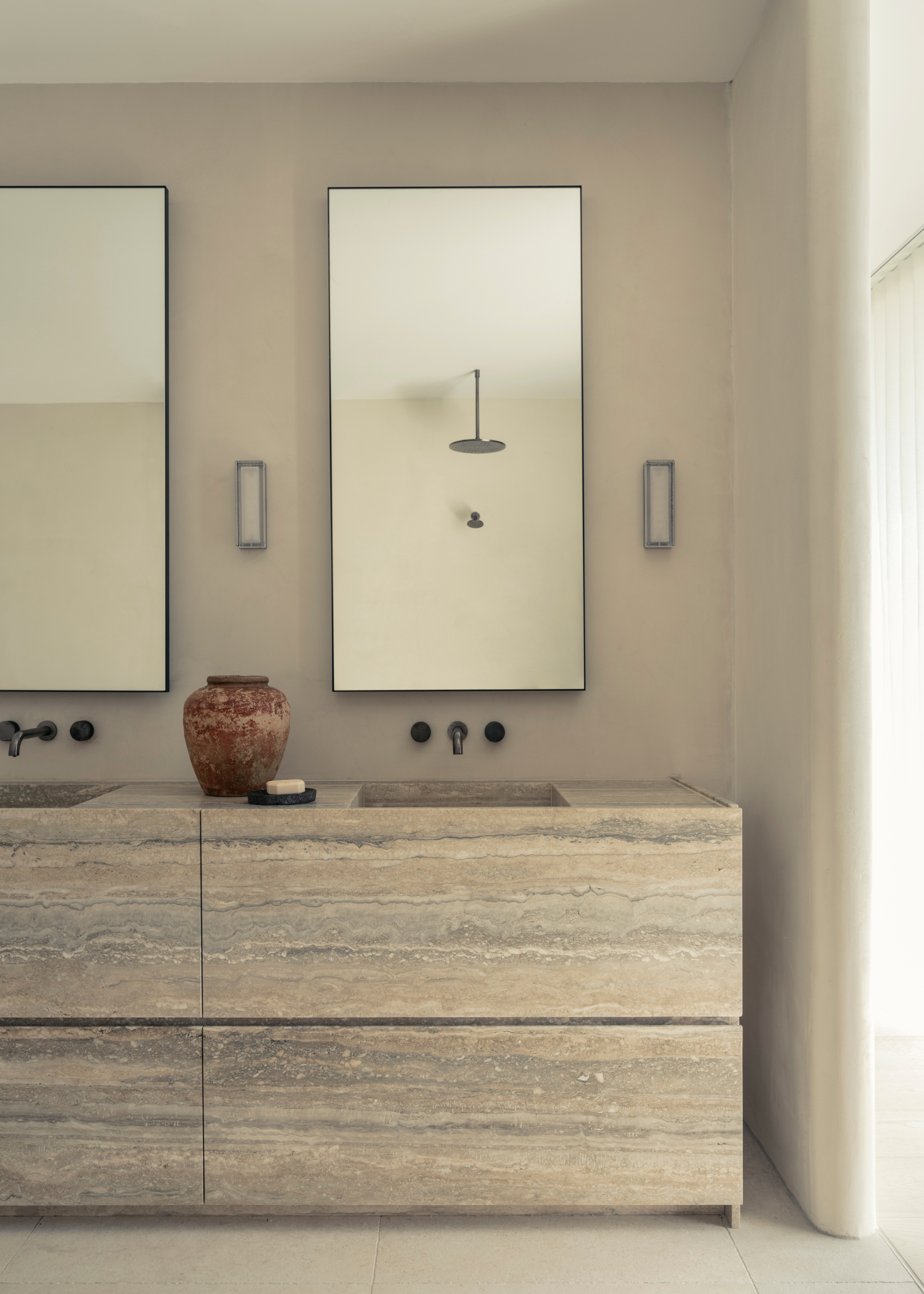 neutral bathroom with a double vanity in travertine