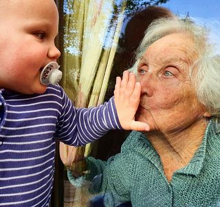 Young child kisses through glass