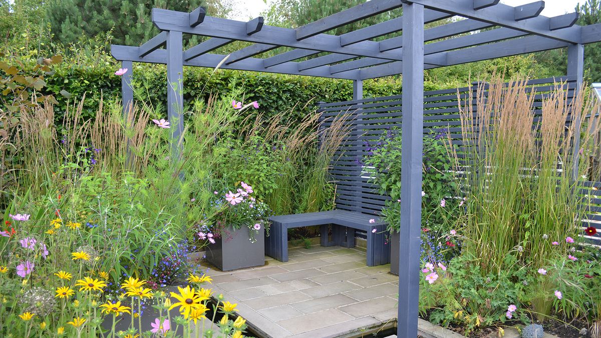 A grey fence and planted hedge boundary 