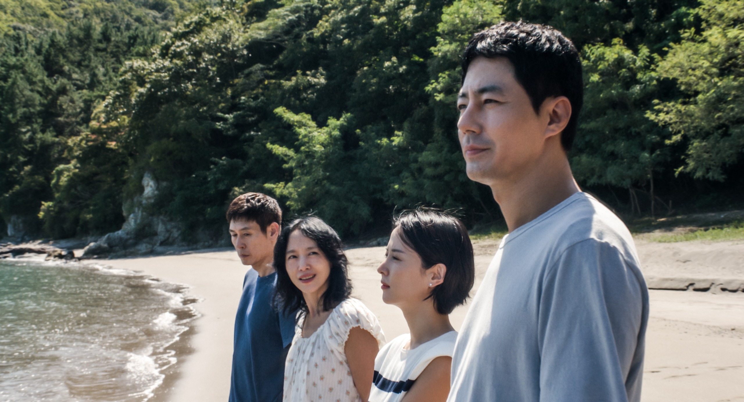 Four Korean people (l-r Sul Kyung-gu as Ho-seok, Jeon Do-yeon as Mi-ok, Cho Yeo-jeong as Ye-ji, and Zo In-sung as Sang-woo) stand on the shoreline of a beach, in a still from 'Possible Love.'