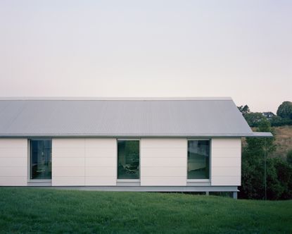 view of minimalist spanish house Casa Guadalupe by studio hanghar, a white house with dark timber accents