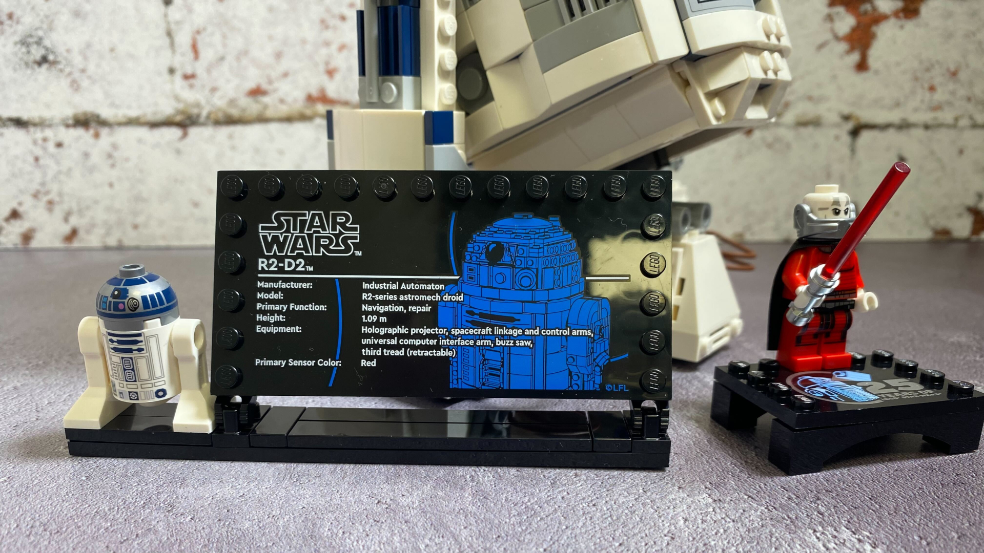 Lego R2-D2 plaque with minifigures and Darth Malek, with the larger R2 model in the background