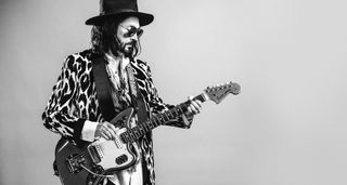 Mike Campbell of the Dirty Knobs, in hat, shades, guitar in hand