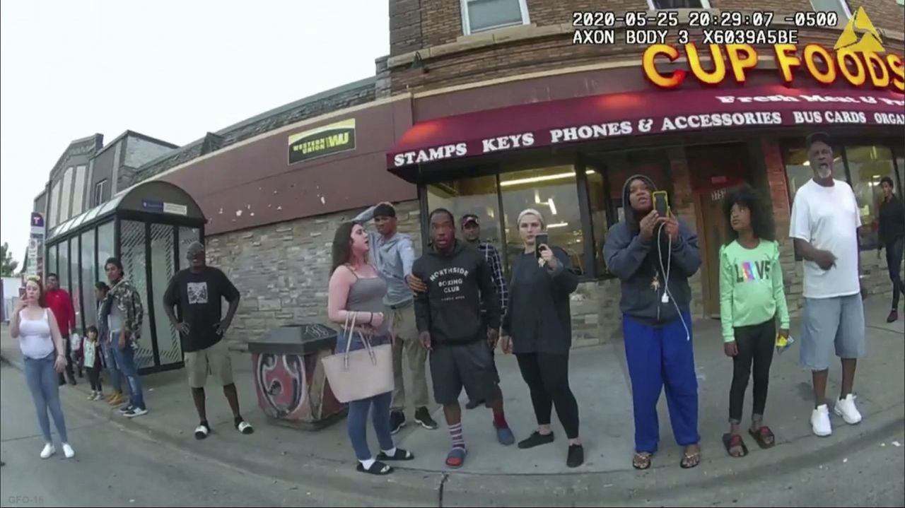 Bystanders watch as George Floyd is arrested in May 2020.