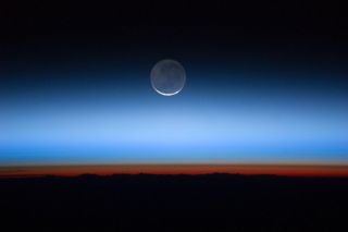 A photo taken aboard the International Space Station captures the divisions of Earth's atmospheric layers. The mesosphere is the upper band of blue; at the top of this band (about 50 miles above Earth) orbit is possible.