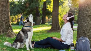 Woman with husky howling in the park