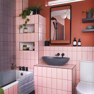 Pink tiled bathroom with sink and mirror