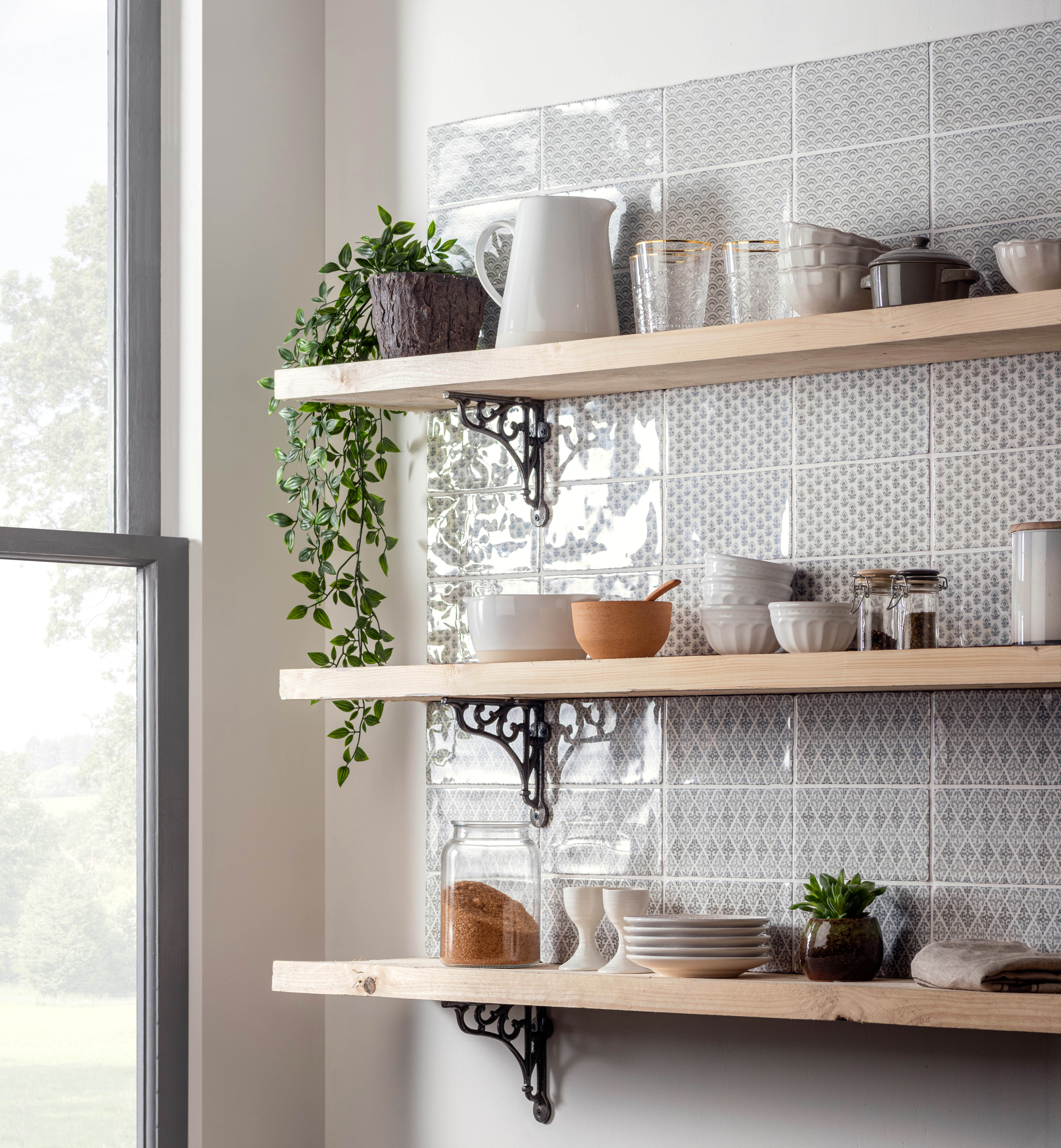 A kitchen with three wooden shelves on grey square patterned tiles