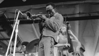 American trumpeter and composer Miles Davis (1926 - 1991) performing at the Newport Jazz Festival at Newport, Rhode Island, 5th July 1969. Behind Davis are Jack DeJohnette on drums and Dave Holland on bass.