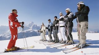 A group taking a ski lesson with an instructor