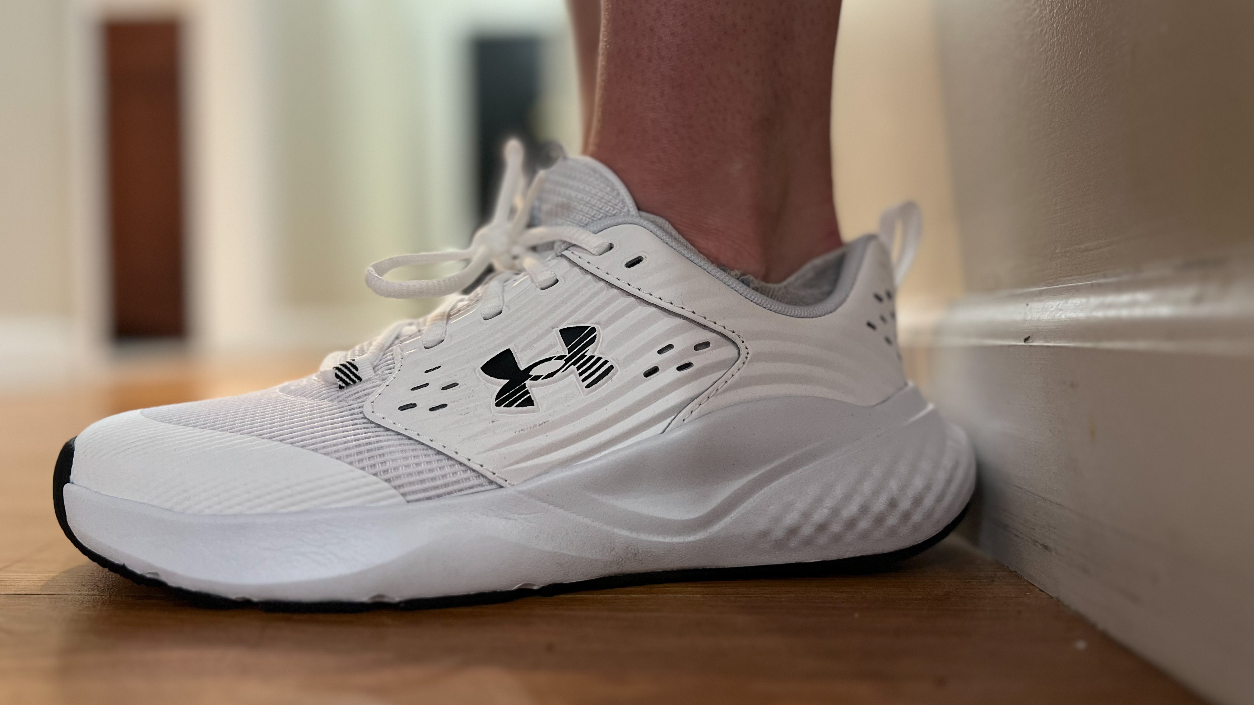 Trainer Jennifer Rizzuto wears the Under Armour Commit 4 cross-training shoes in her hallway.