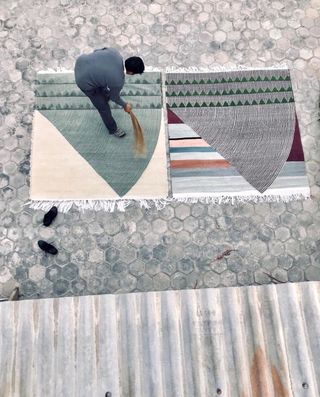 Birdseye view of man sweeping rug