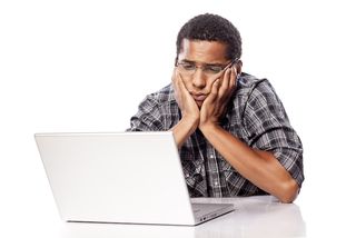 A man stares forlornly at his computer screen.